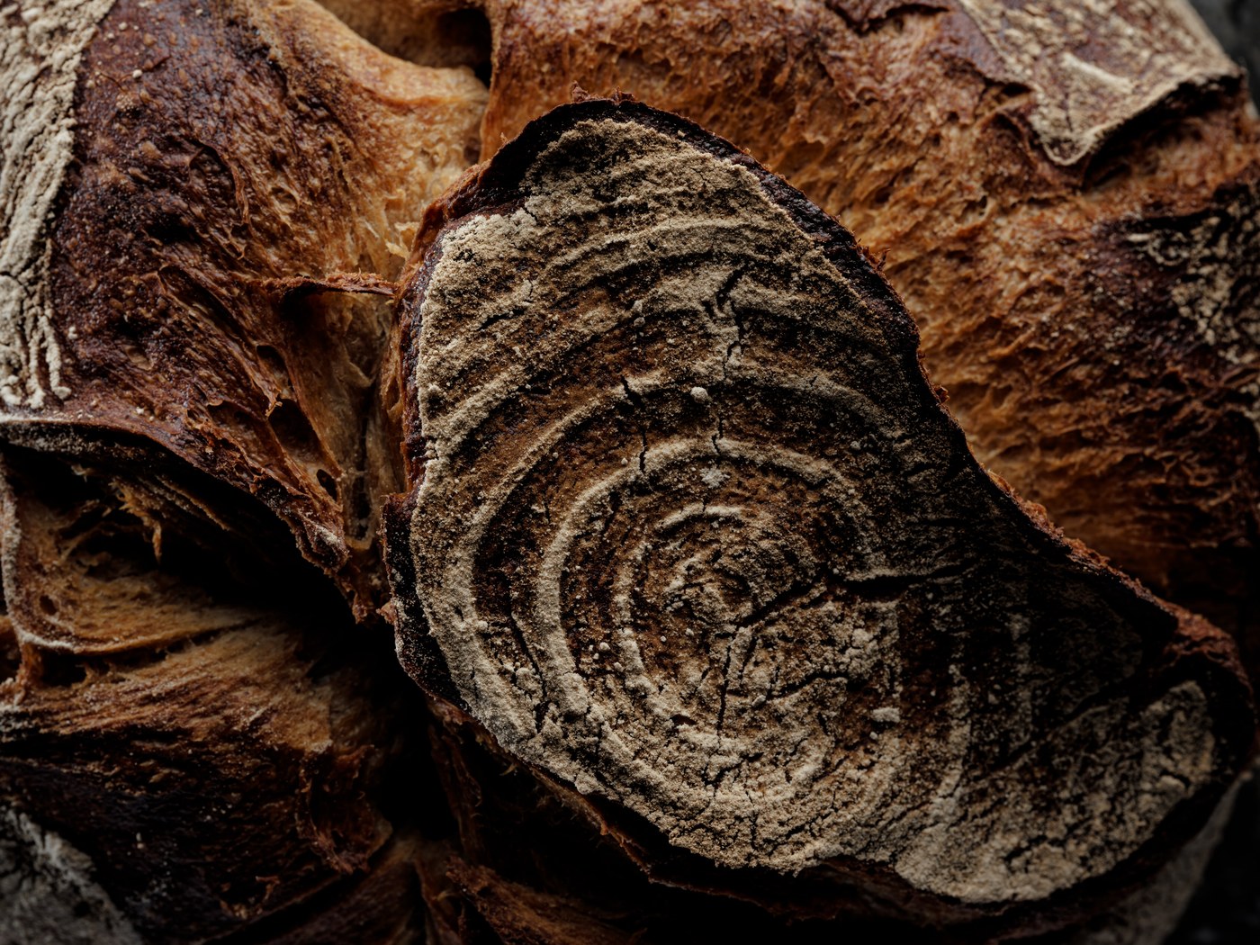 Close-up of Öfferl organic natural sourdough bread with a flour-dusted, deeply cracked crust.